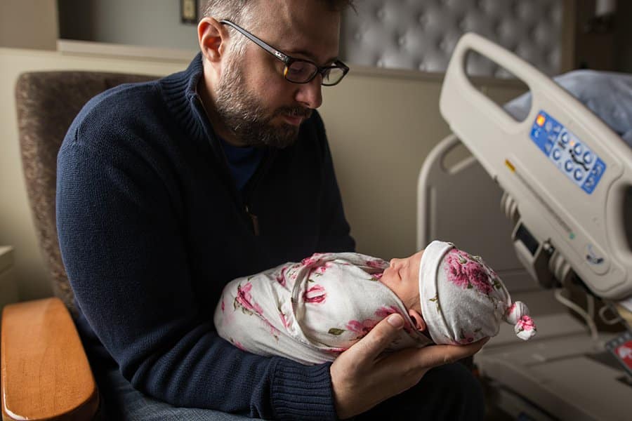 dad with newborn baby on hospital bed in pittsburgh for a fresh 48 session
