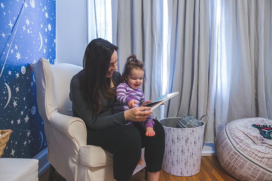 mom reading to daughter in pittsburgh bedroom 