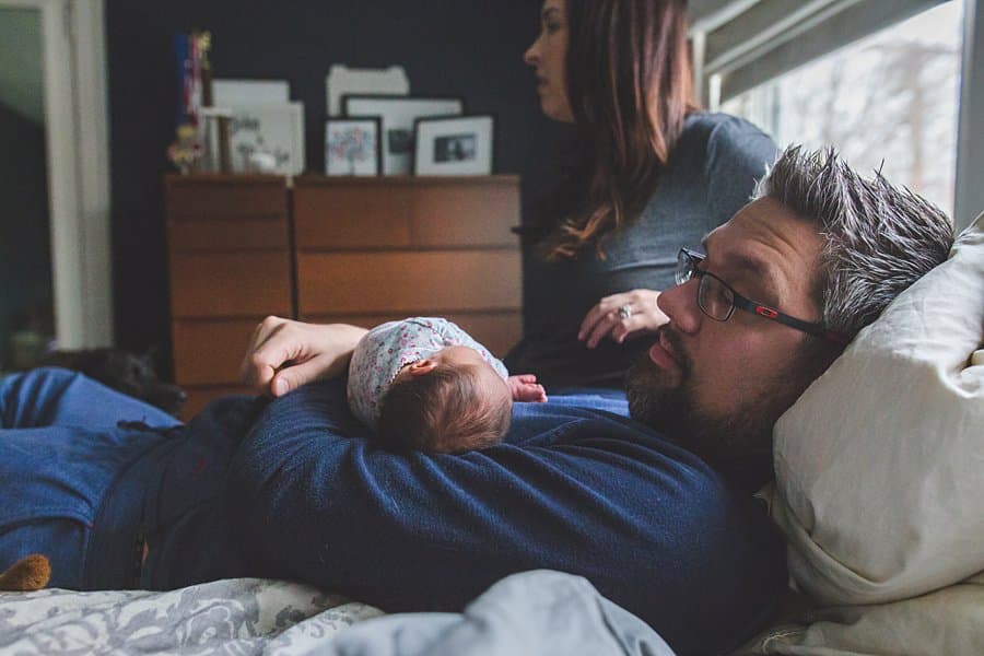 pittsburgh dad and newborn baby on bed in home 