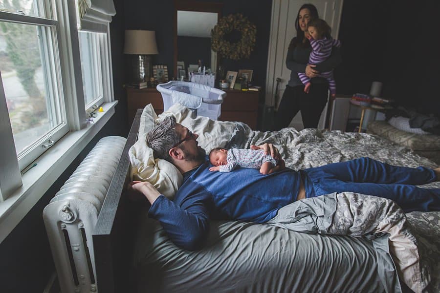 pittsburgh dad and newborn baby on bed in home 