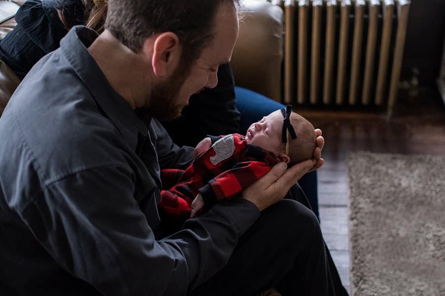 father holding newborn baby for lifestyle photo session in pittsburgh