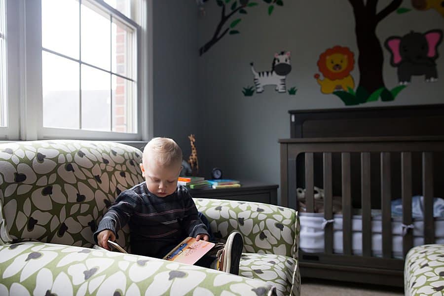 little boy reads book in pittsburgh home bedroom