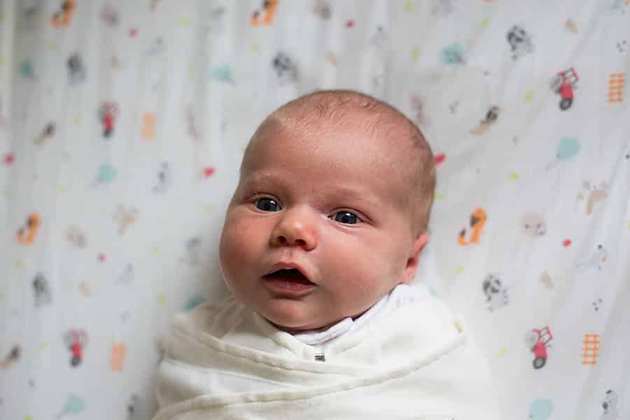 newborn baby in crib in pittsburgh home nursery