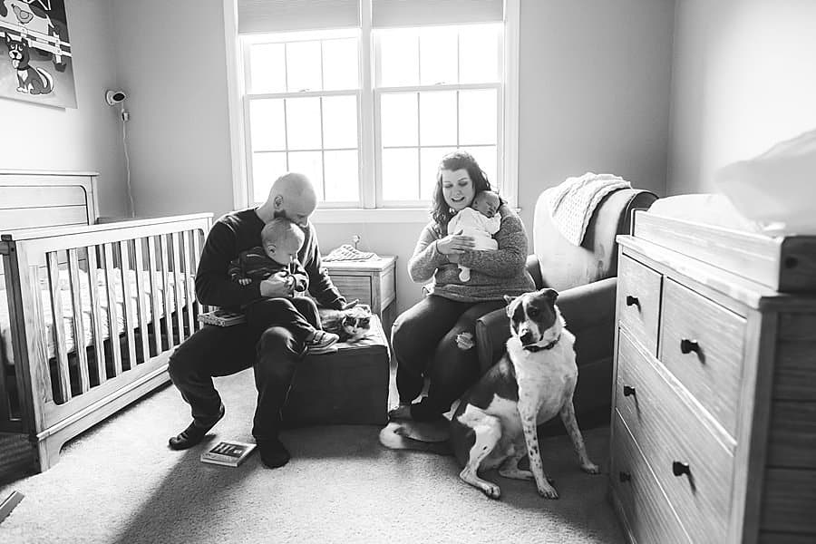 family sitting in baby nursery in pittsburgh home with dog