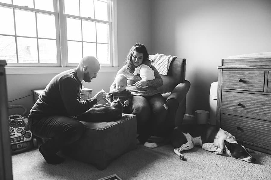 family sitting in baby nursery in pittsburgh home with dog