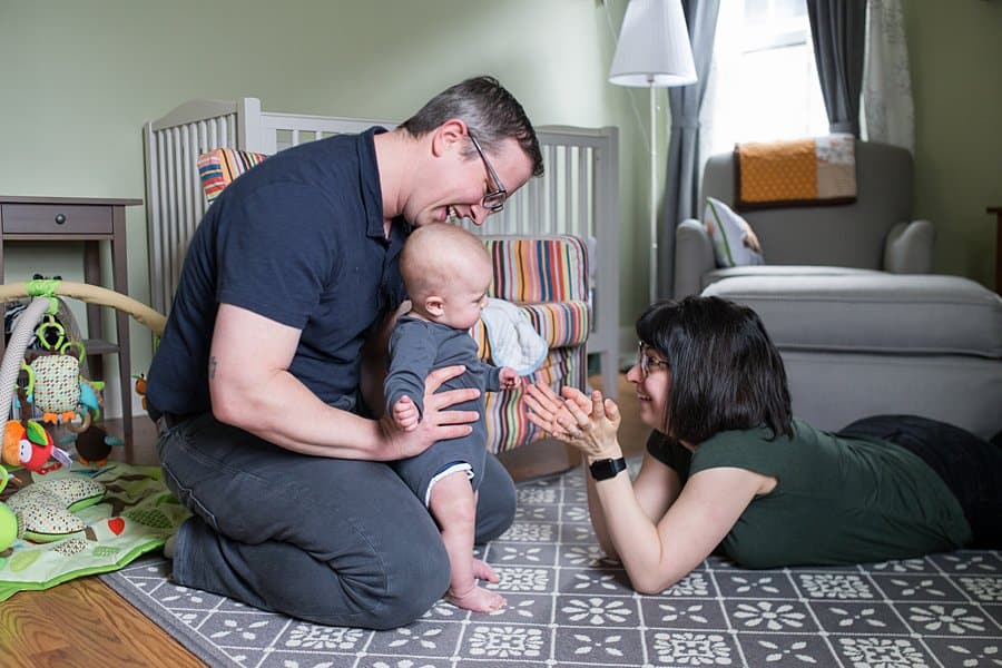 mom dad and baby in nursery for lifestyle newborn photo session in pittsburgh 