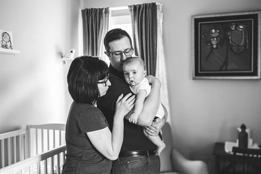 mom dad and baby in nursery for lifestyle newborn photo session in pittsburgh 
