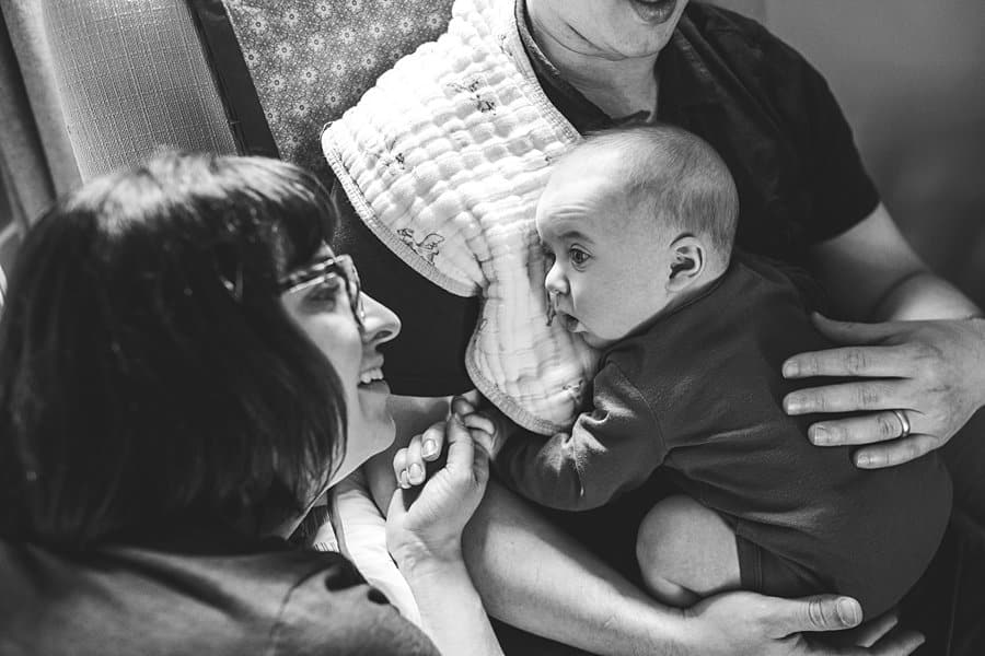 mom dad and three month old baby sitting on chair in South Hills Pittsburgh Baby photographer  nursery 