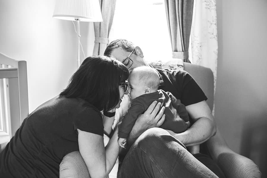 mom dad and three month old baby sitting on chair in South Hills Pittsburgh Baby photographer  nursery 
