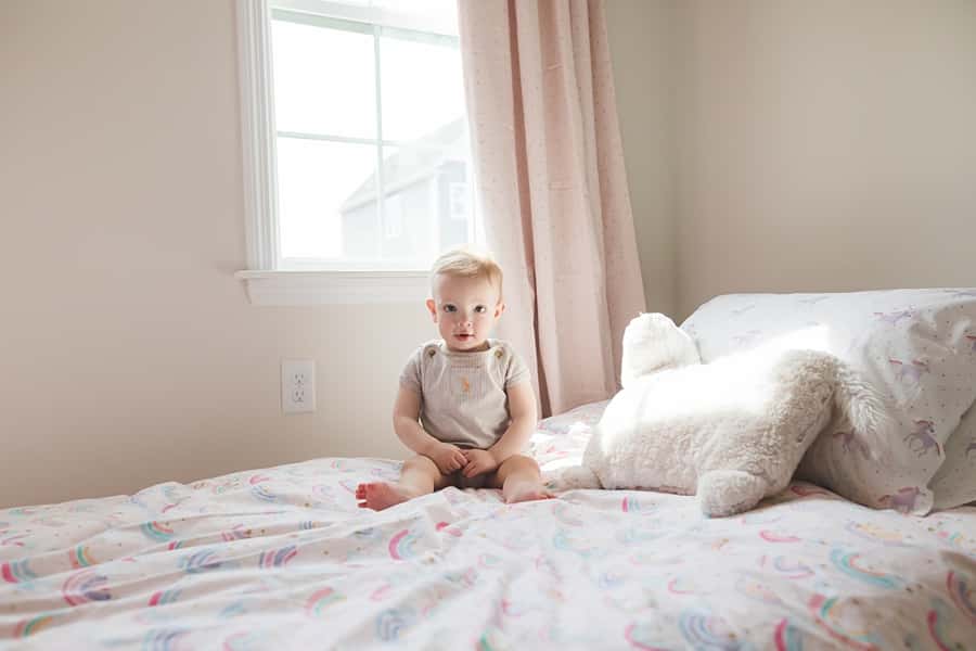 little boy on bed in window light for family photo session