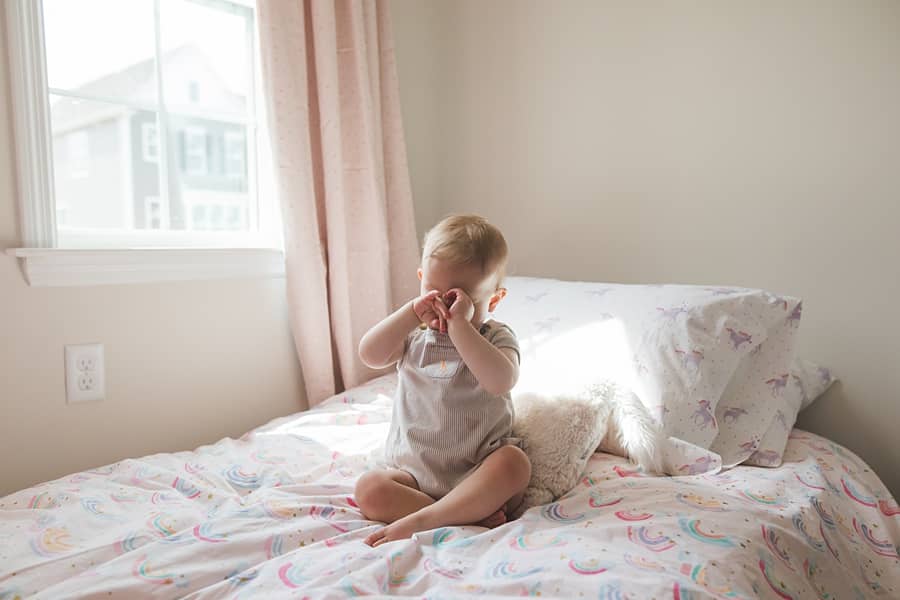 little boy on bed in window light for family photo session