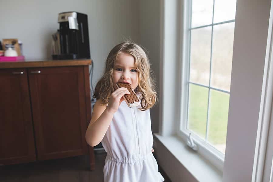 little girl eating an ice cream sandwich in bridgeville home