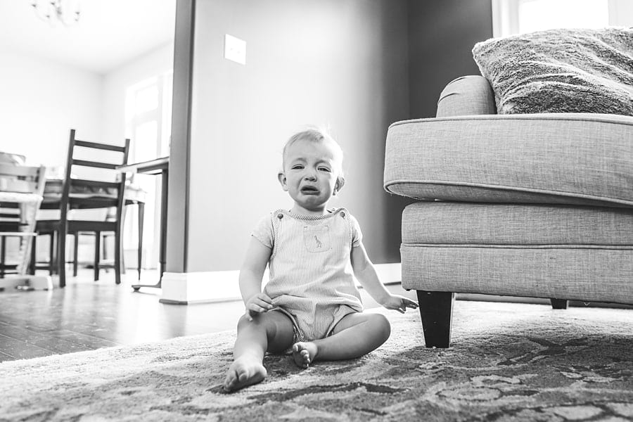 baby crying on floor in bridgeville home for family photo session