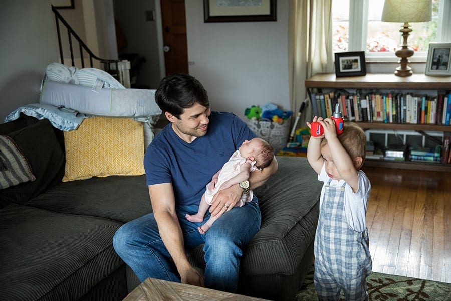 dad with newborn and toddler sitting on couch of pittsburgh home for newborn photo session