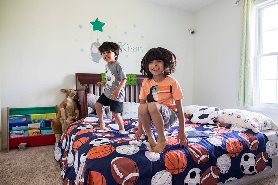 children bouncing on the bed of their pittsburgh home for a family photo session