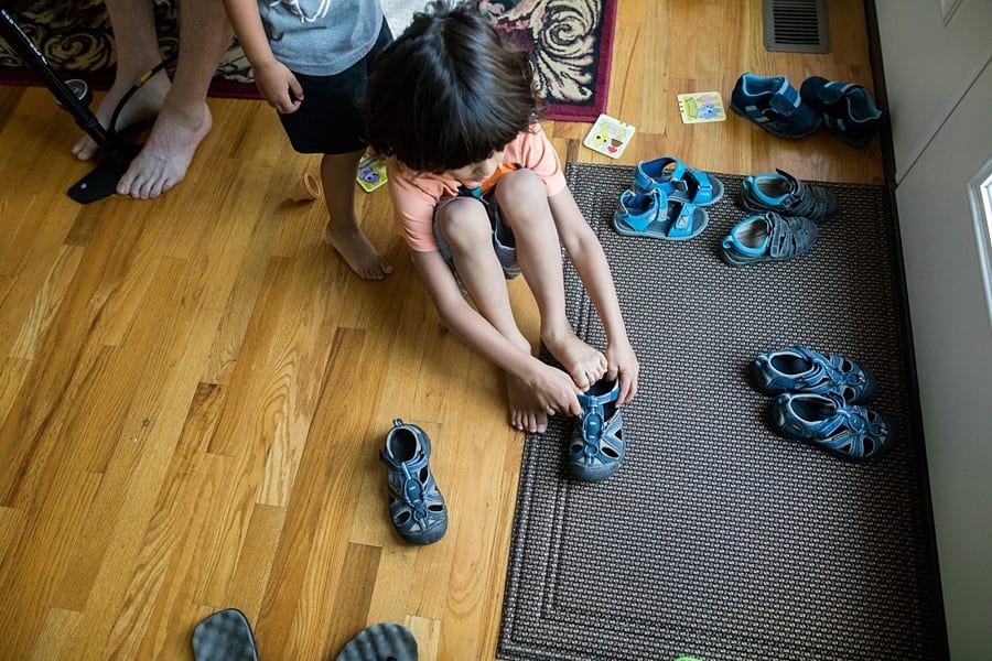 boy putting on shoes in pittsburgh home