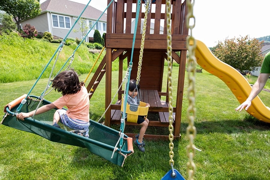 family playing on swing set of pittsburgh home for family photo session