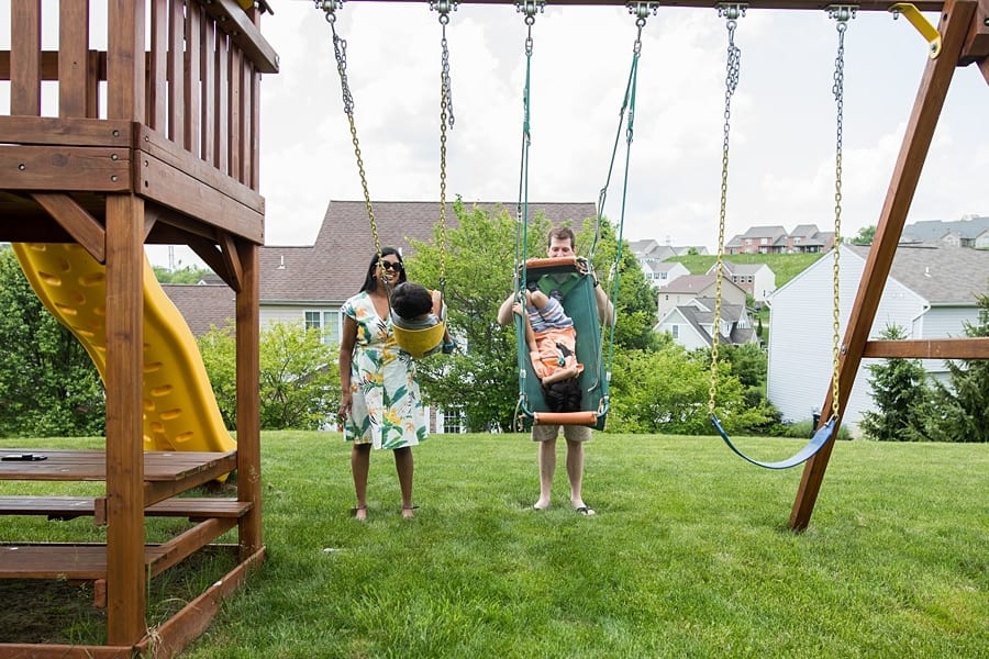 family playing on swing set of pittsburgh home for family photo session