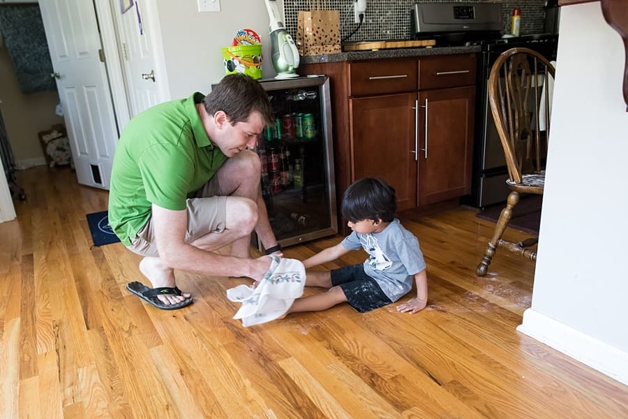 dad cleaning flour off of sons feet during documentary family session