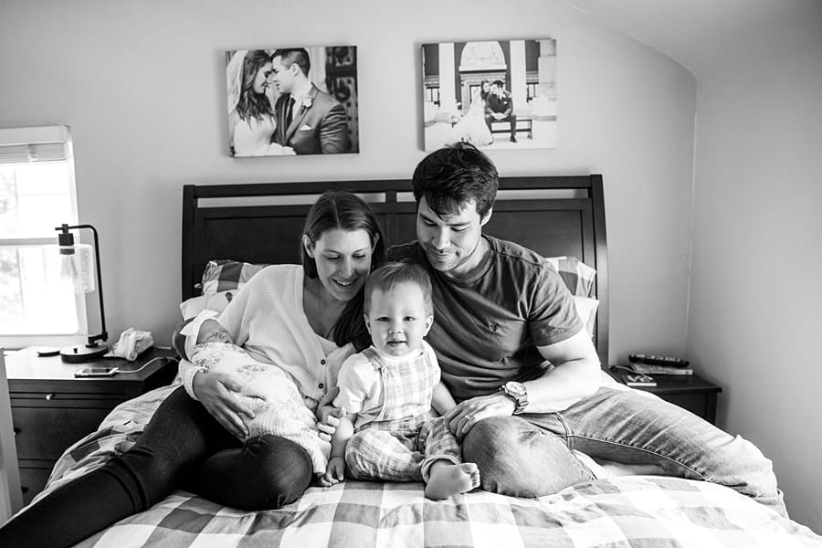 family on bed in pittsburgh home for photo newborn photo session