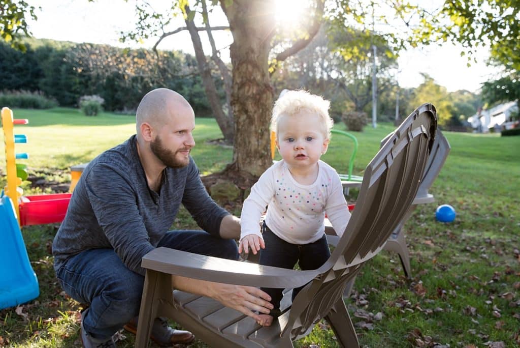 dad with daughter on lawn chair in sunset for a fun and stress free family photo session