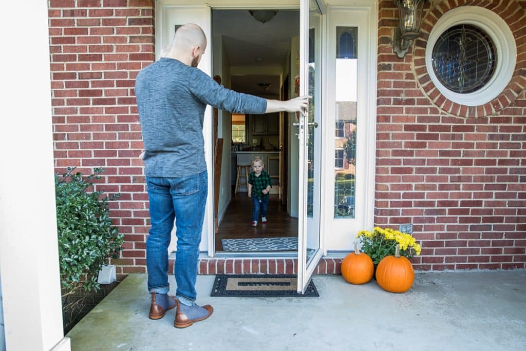 dad holds door open for toddler son Family Photos at home in Bridgeville