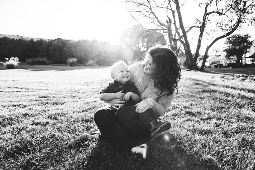 mom with son in grass smiling at each other  The number one tip to get your kids to behave during a photo session