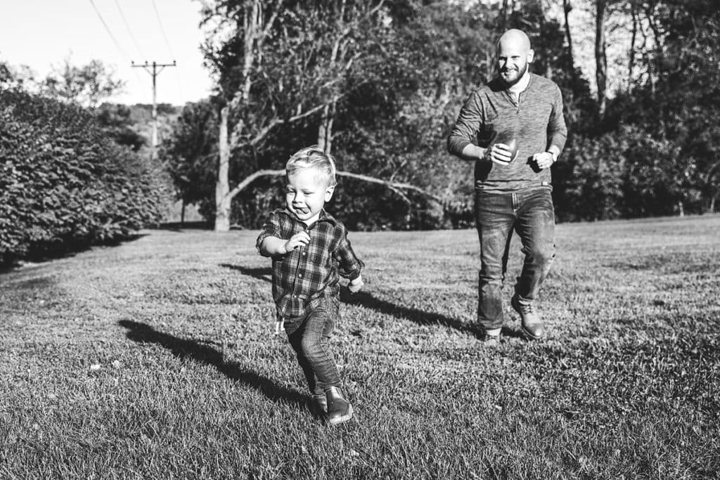 dad chasing son in grass