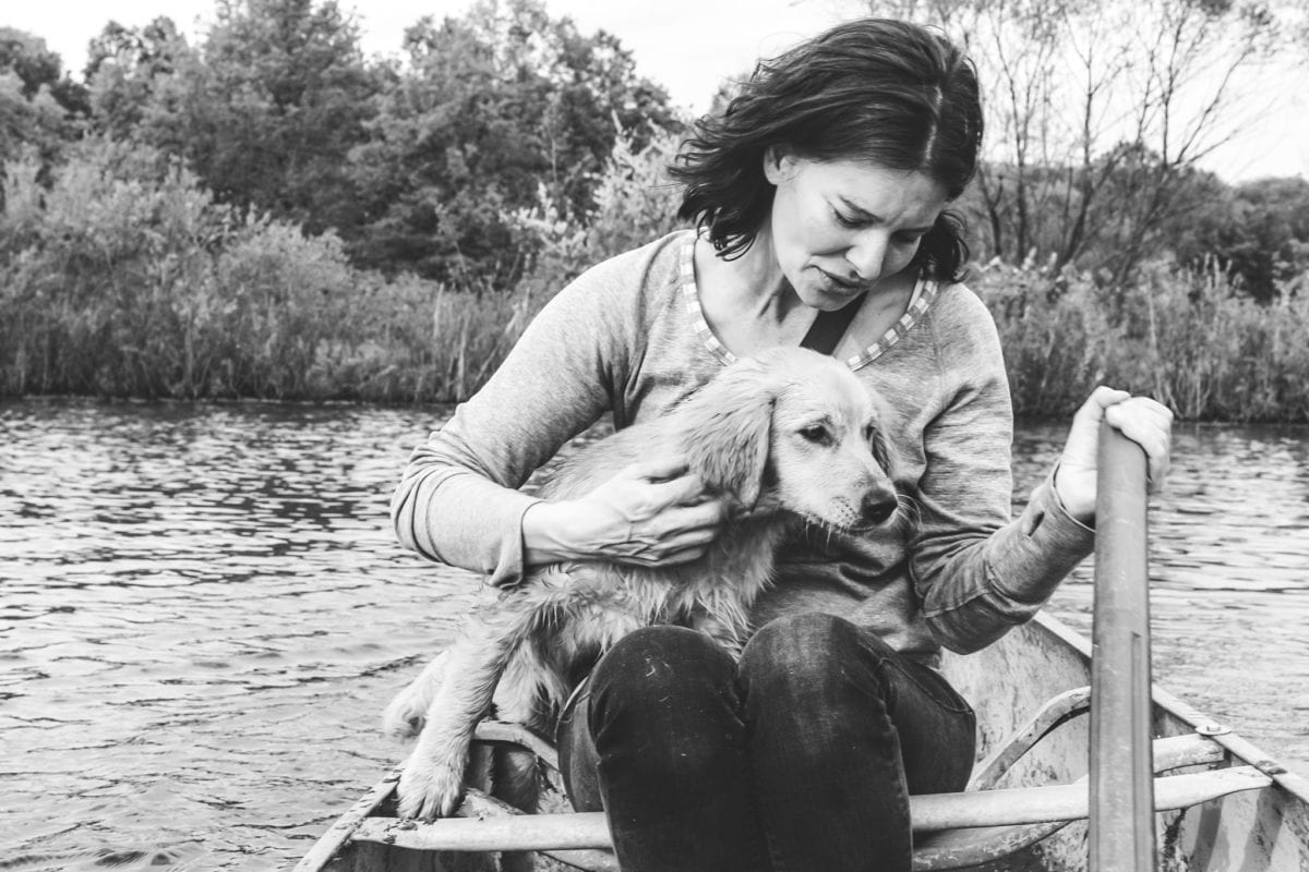 mary beth miller on her farm in a canoe with a dog