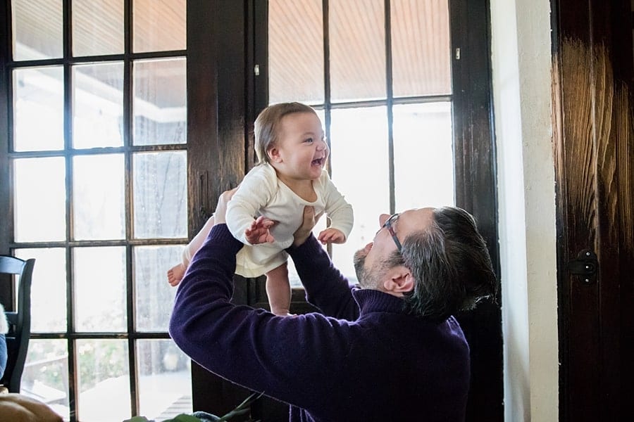 family photos at home before moving dad lifting baby in air inside pittsburgh home