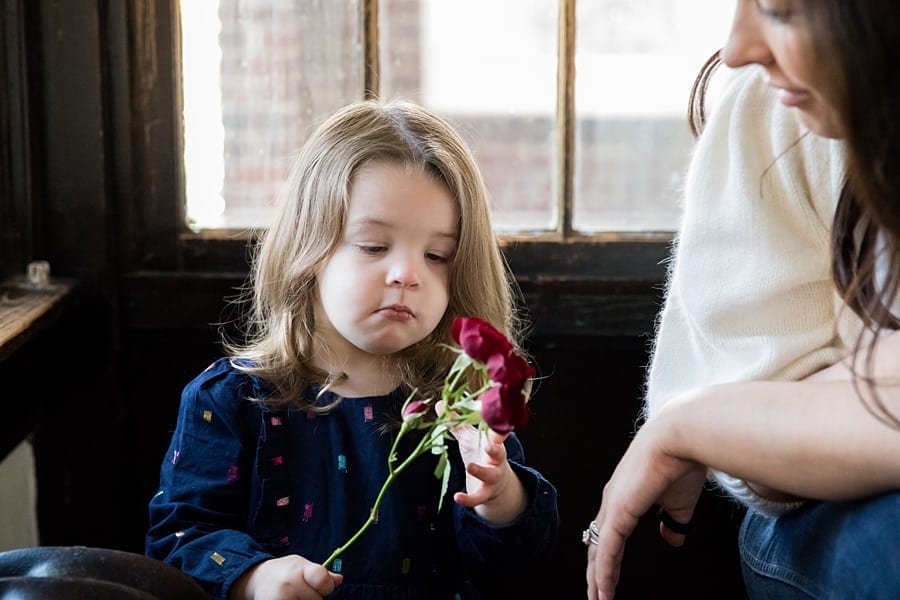 little toddler girl with flowers for in home photo session