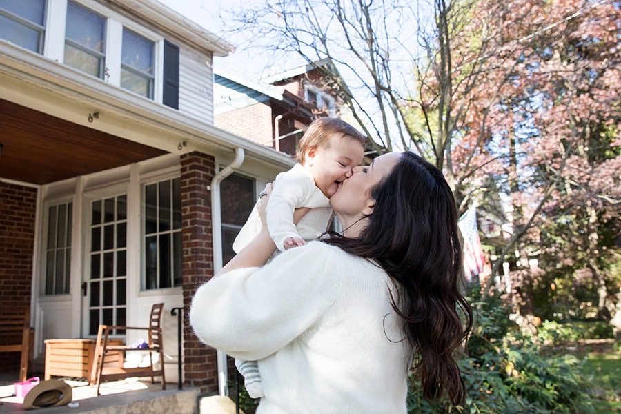 mom and baby on porch for lifestyle family photo session at house in regent square