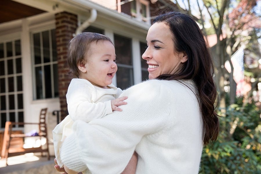 mom and baby on porch for lifestyle family photo session at house in regent square