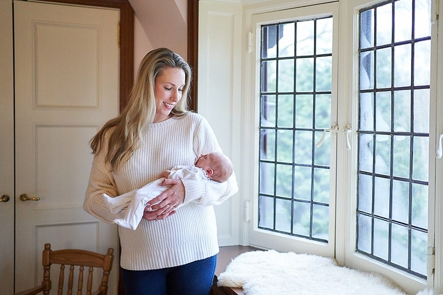 newborn baby in moms arms in nursery