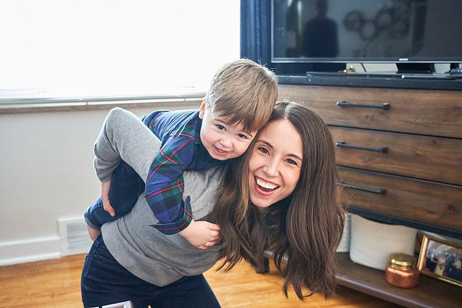 toddler son on moms back for a lifestyle family photo session