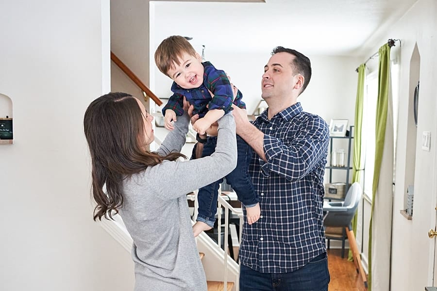 mom dad and toddler son in living room for a lifestyle family photo session