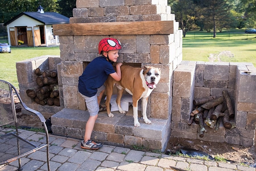 little boy and boxer on patio