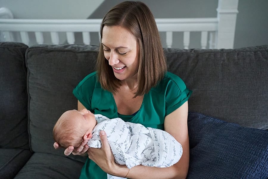 mom looking at newborn son on living room couch
