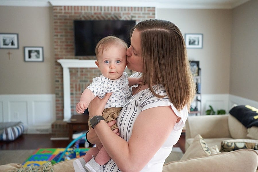 mom holding baby boy in pine township living room for lifestyle photo session