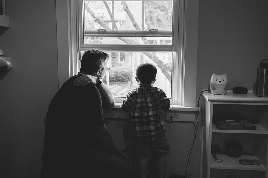 father and son looking out the window