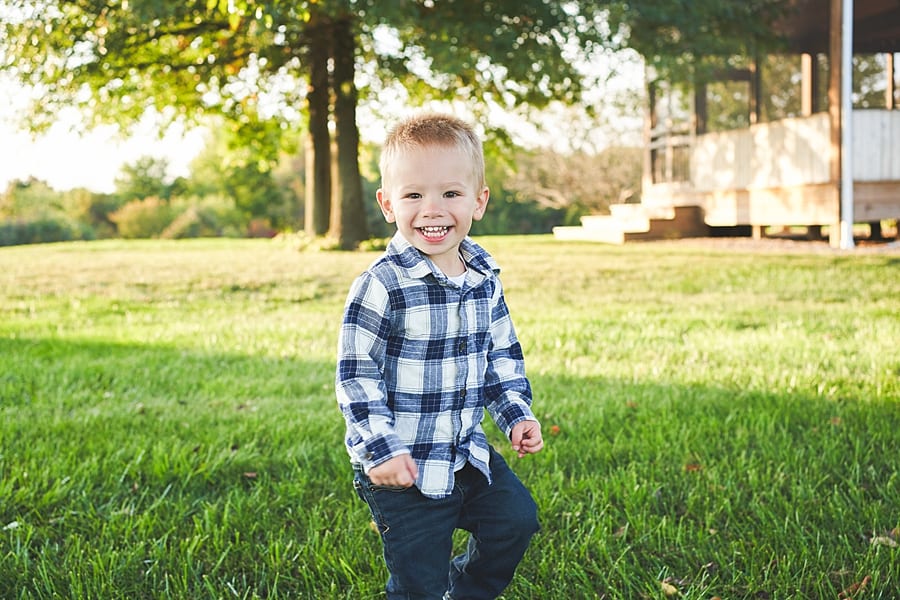Toddler boy running and laughing looking into the camera