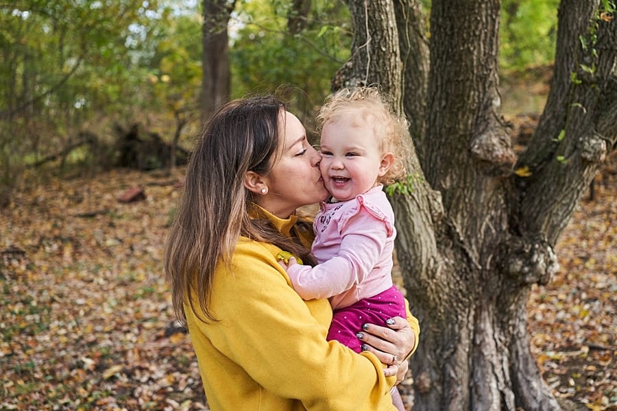 mom kissing daughter in backyard of pittsburgh home