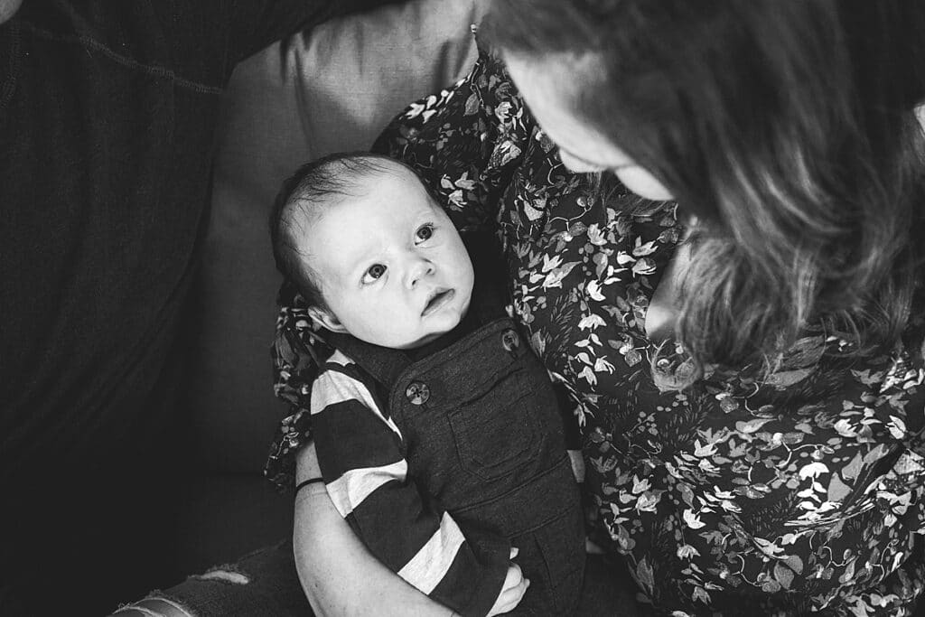Baby boy looking into his mothers eyes while she is holding him