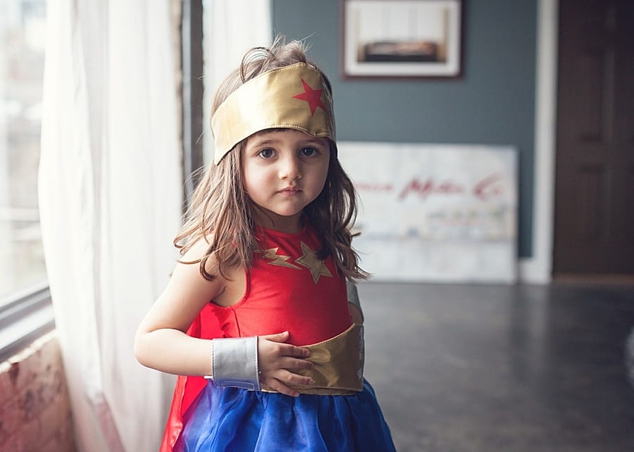 little girl in super hero costume Preparing for a family photo session at your Pittsburgh home