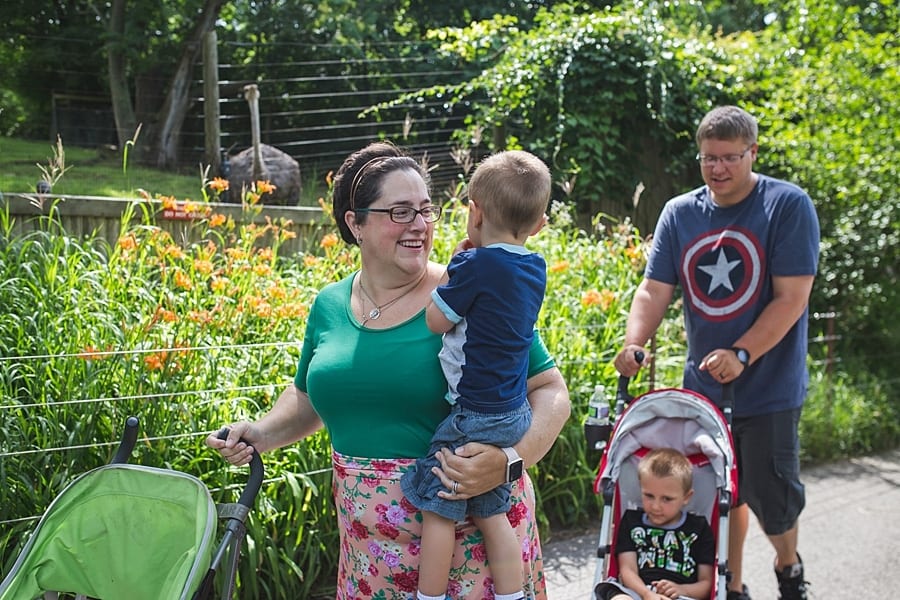 10 ideas for an on-location family photo session around Pittsburgh zoo mother caring son and father pushing little boy and stroller in front of the ostrich