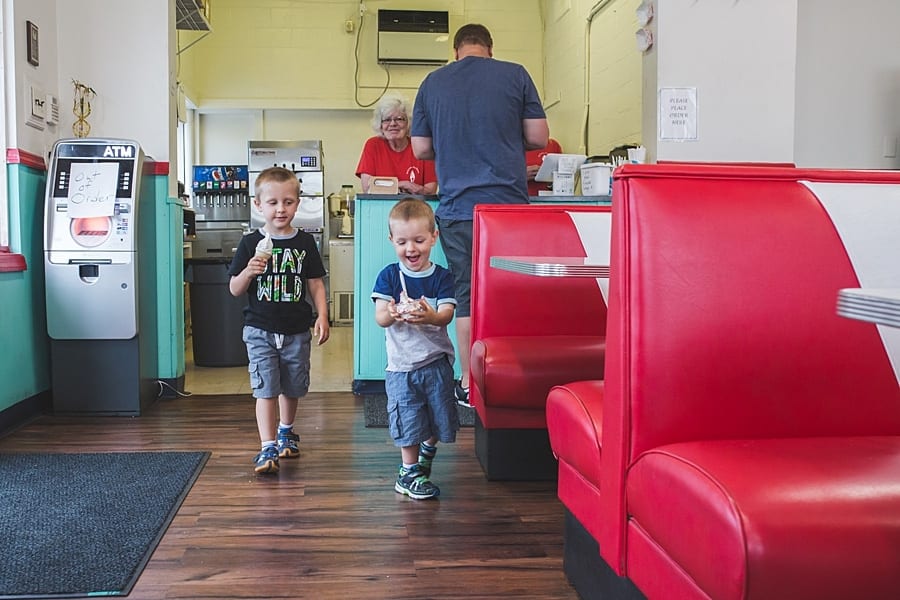 10 ideas for an on-location family photo session around Pittsburgh Brothers caring ice cream away from counter to both at ice cream parlor