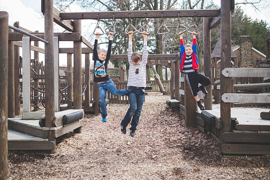 10 ideas for an on-location family photo session around Pittsburgh three brothers hanging from monkey bars on wooden playground
