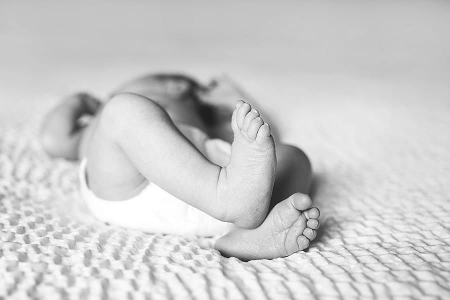 baby feet on bed with window light Mars area newborn baby Photographer