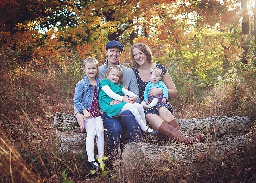 family sitting on log with fall foliage for a Poland ohio family photo session