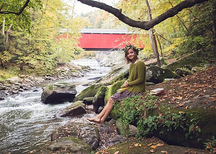 girl sitting by slippery creek and Harris covered bridge at McConnells mill park for a senior photo session